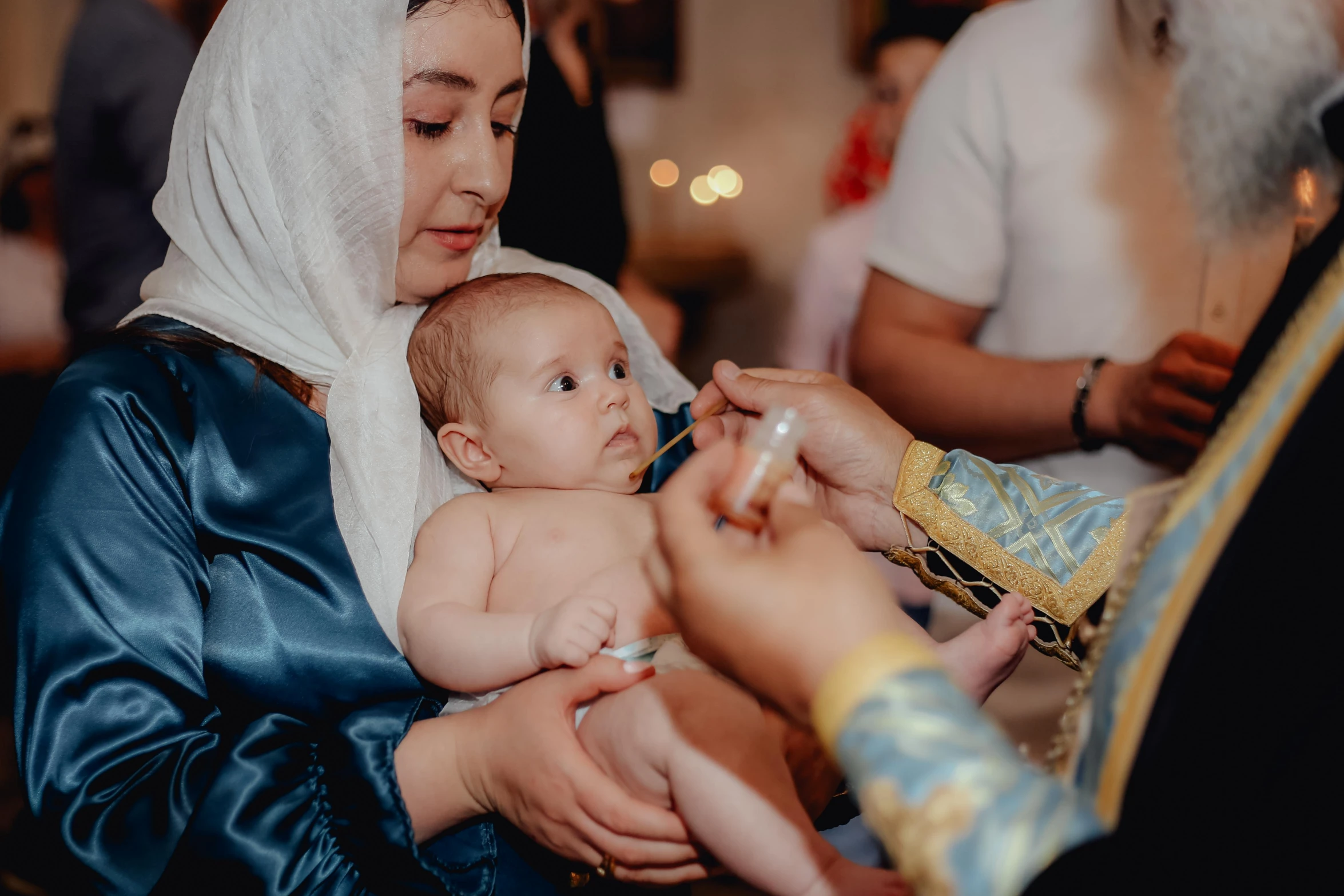 a woman holds a baby while being examined by an adult