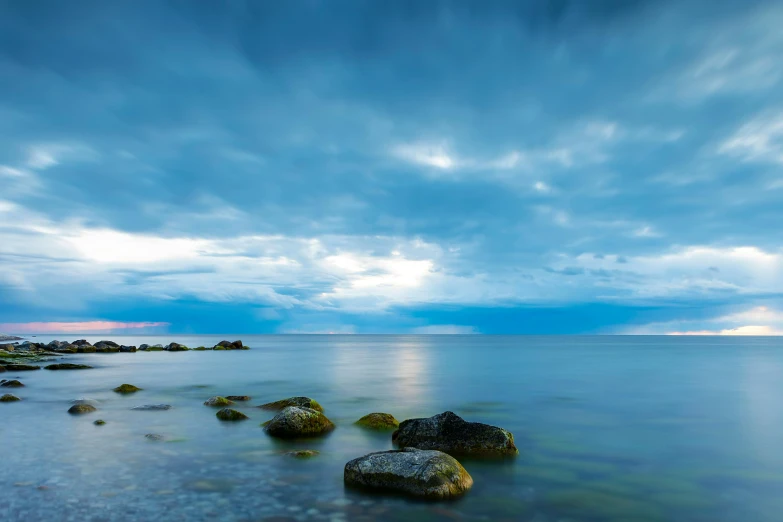 the sky is covered in white clouds over the water