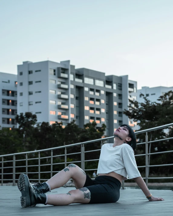 a woman laying on the ground in front of a building