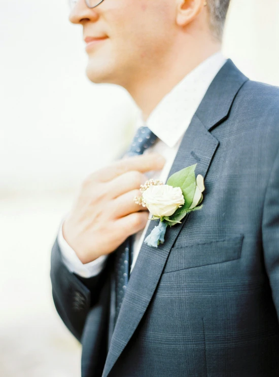 a man wearing a suit with a small flower on his lapel