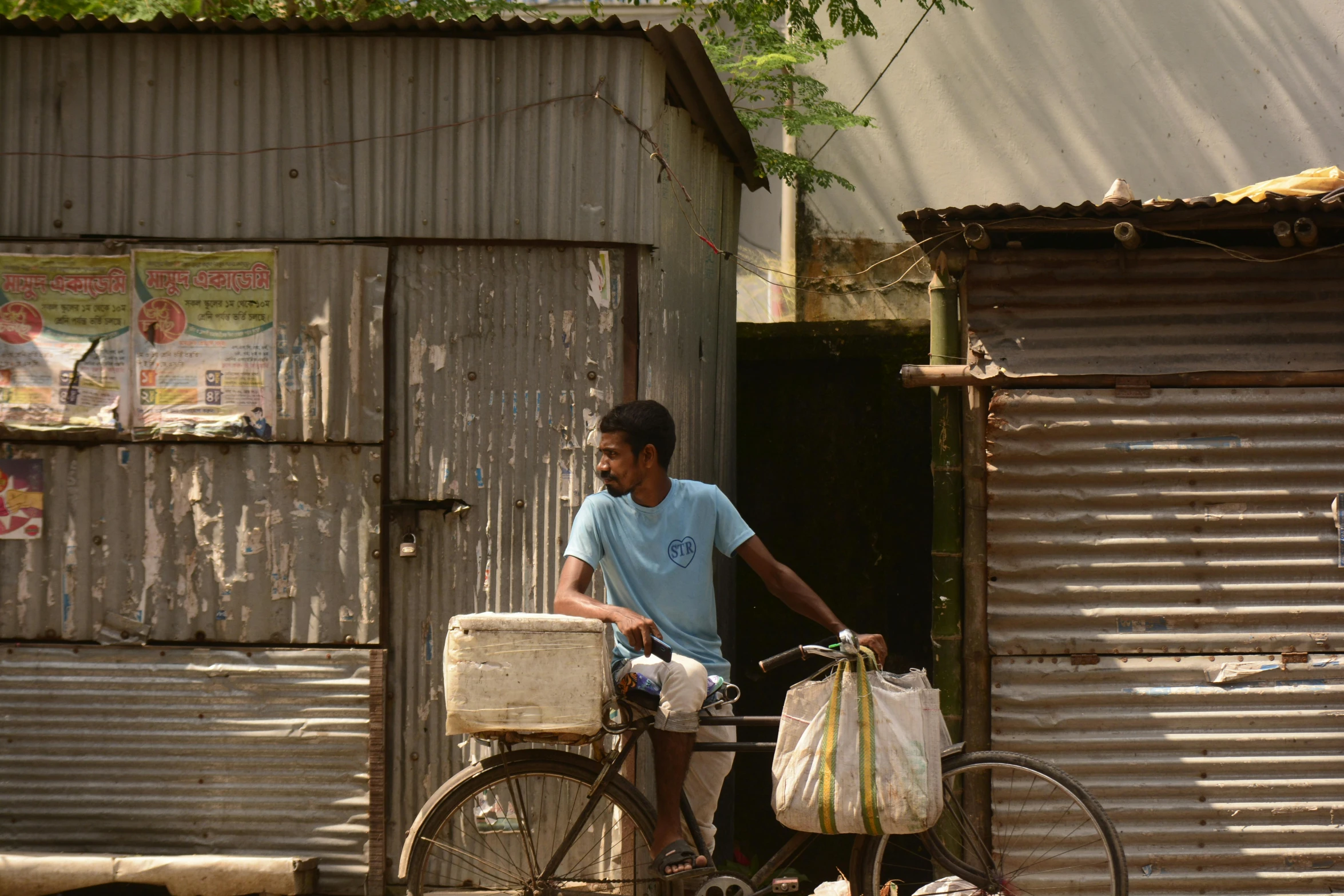 a man riding a bike near a wooden building