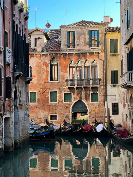 gondola docked outside of a stone building next to water