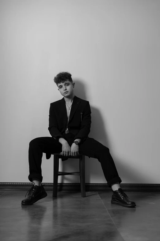 black and white pograph of a person wearing suit sitting down