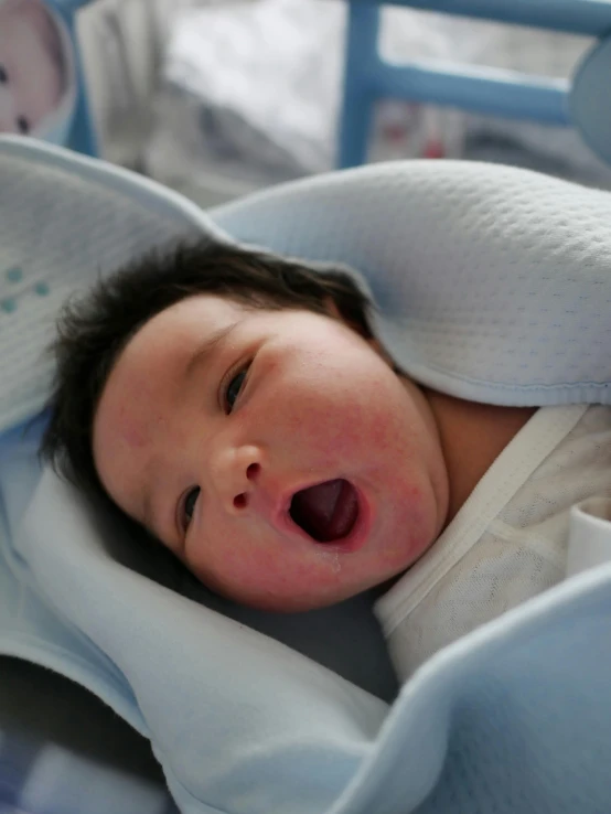 a little child is yawning in the crib