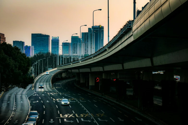 cars traveling on the highway in front of tall buildings