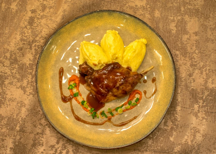 a plate with meat and yellow sauce on it