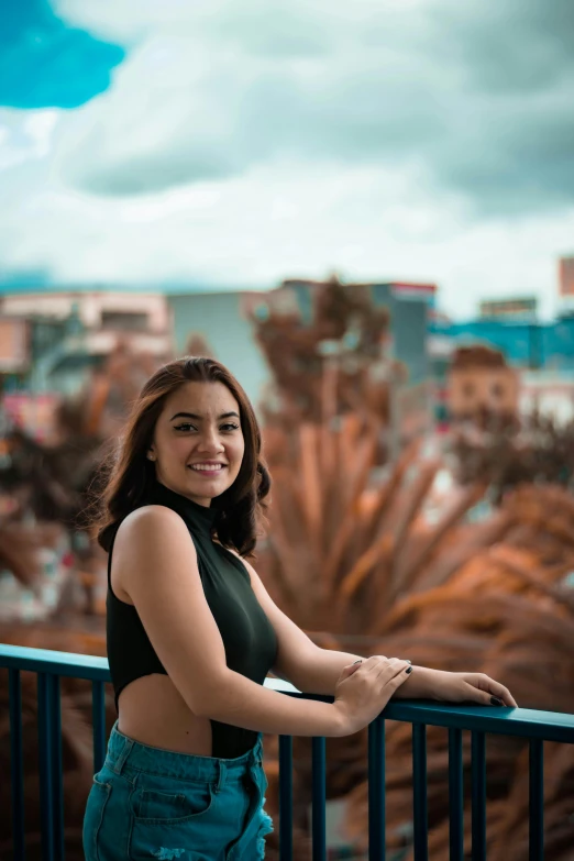 a woman stands on a railing in the city