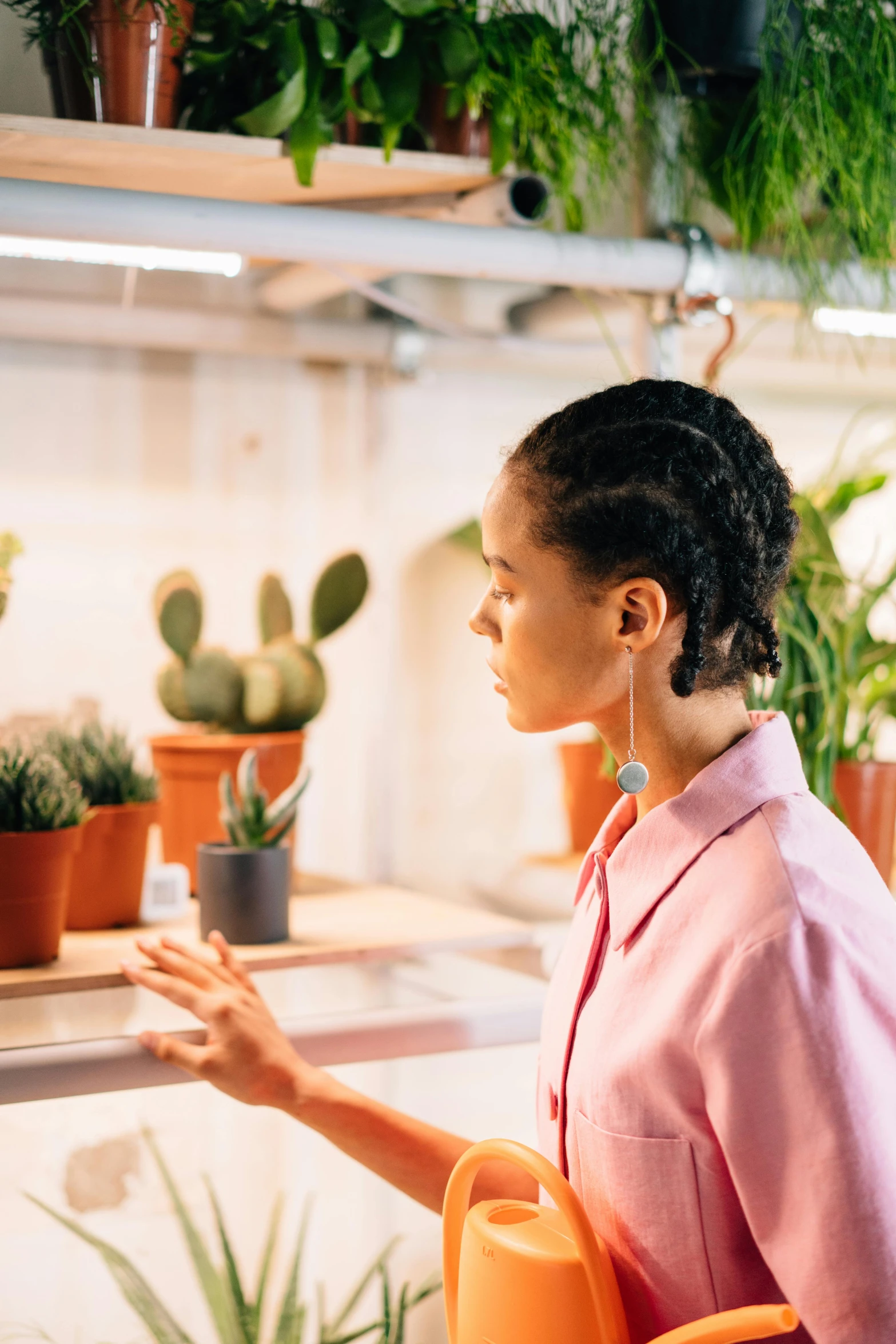 woman sitting in a chair with various plants behind her