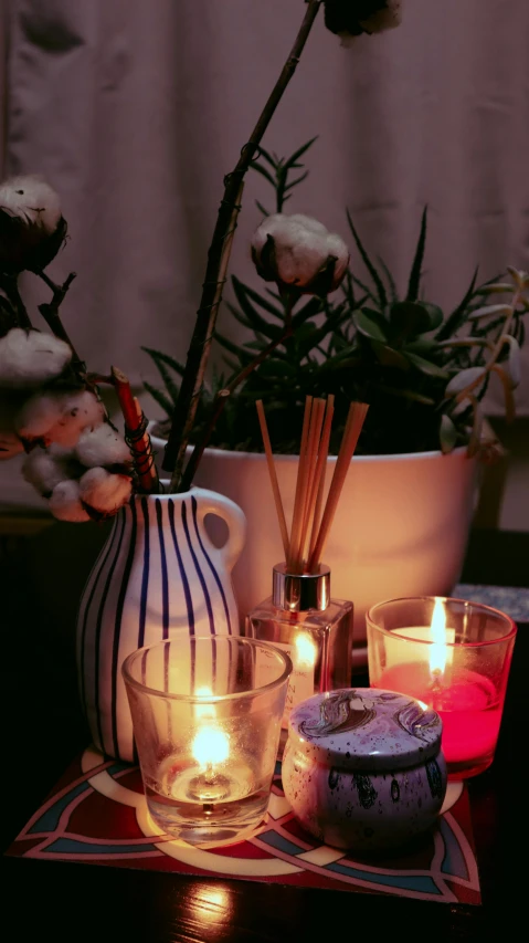 the vases are next to two candles on a tray