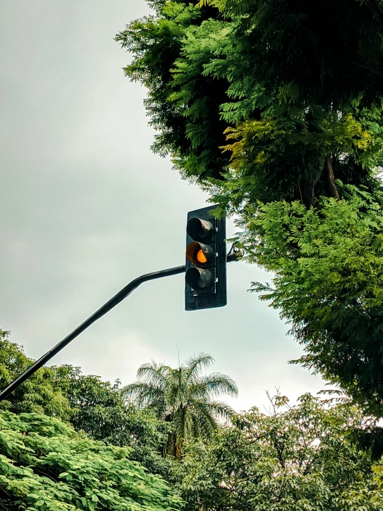 a red traffic light hanging from the side of a metal pole