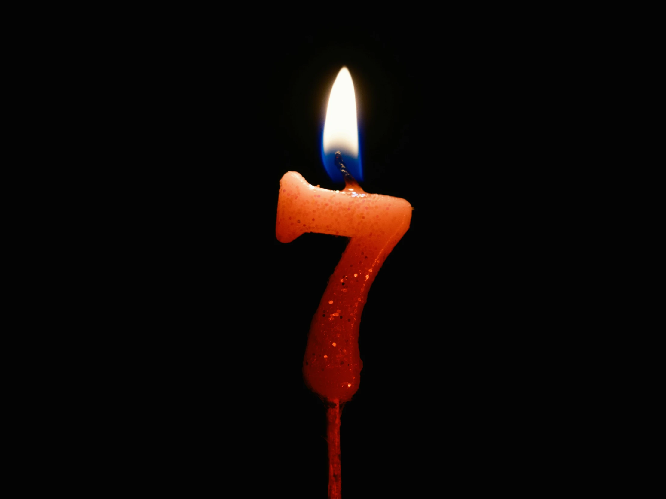 red and blue candle with white candles on black background