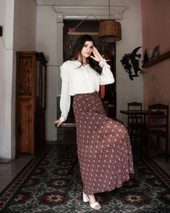 a young woman standing in a hallway wearing a white blouse