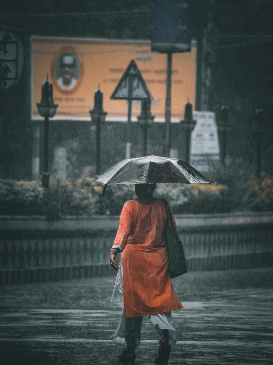 a woman walking in the rain with an umbrella