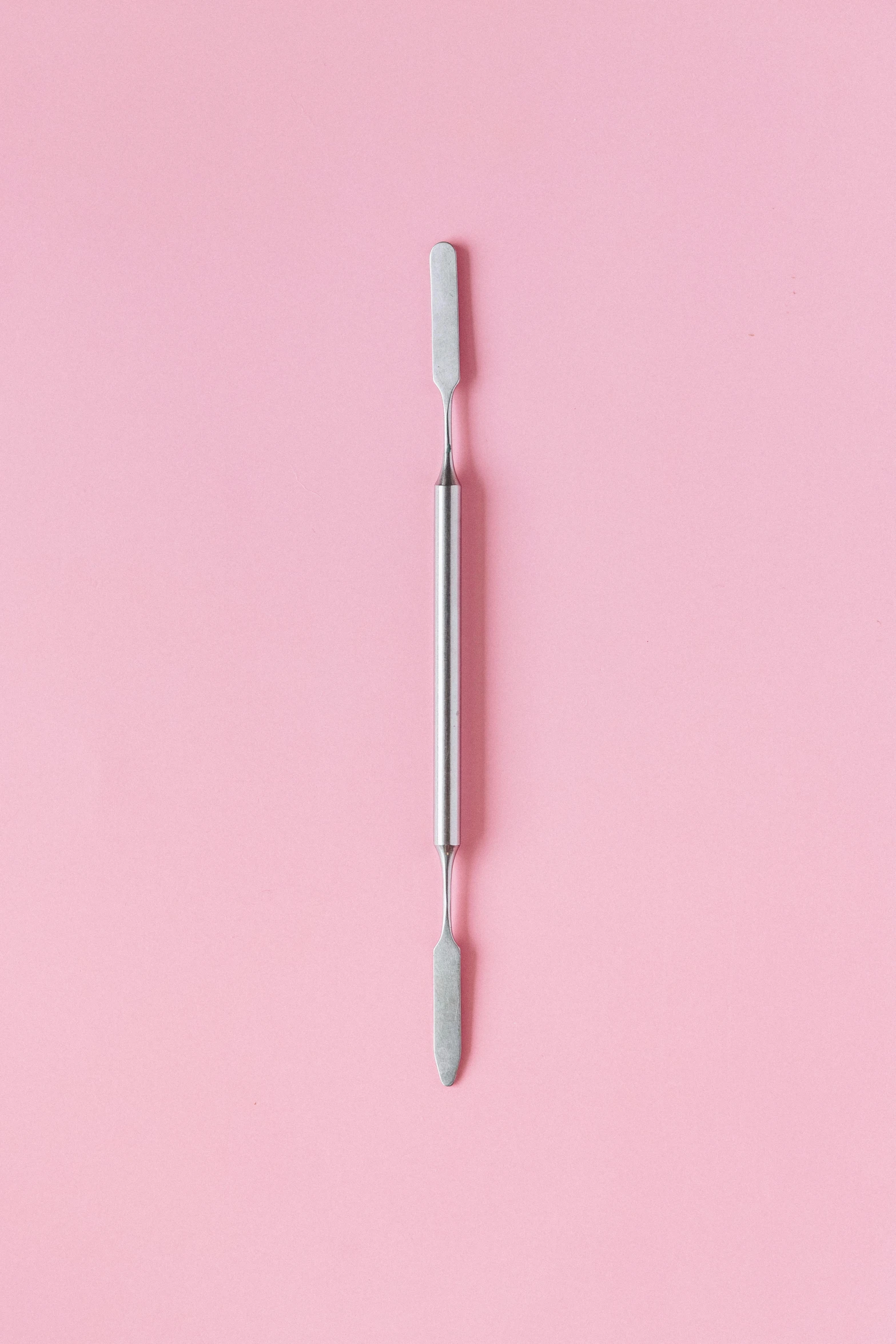 an empty toothbrush on a pink background