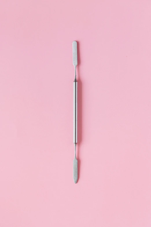 an empty toothbrush on a pink background