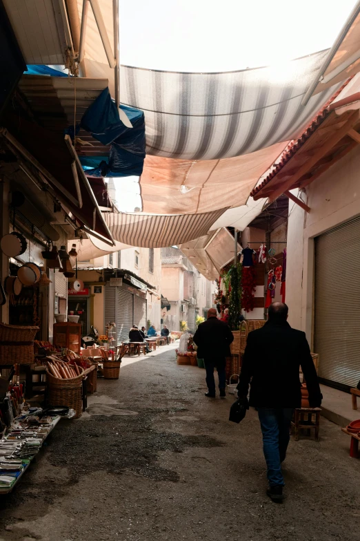 people are walking down an alley between two buildings