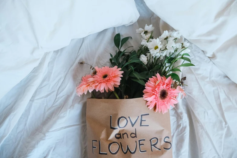 some pink and white flowers in a brown bag