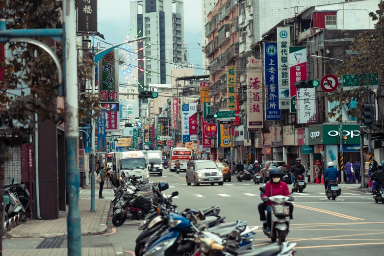 people riding motorcycles on a busy street with asian signs in the background