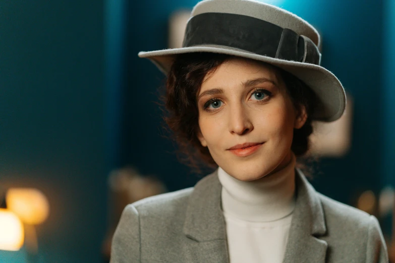 woman in gray hat standing near light in room