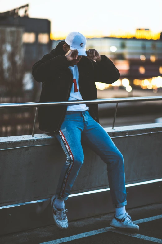 a person is leaning against a rail with their hands up