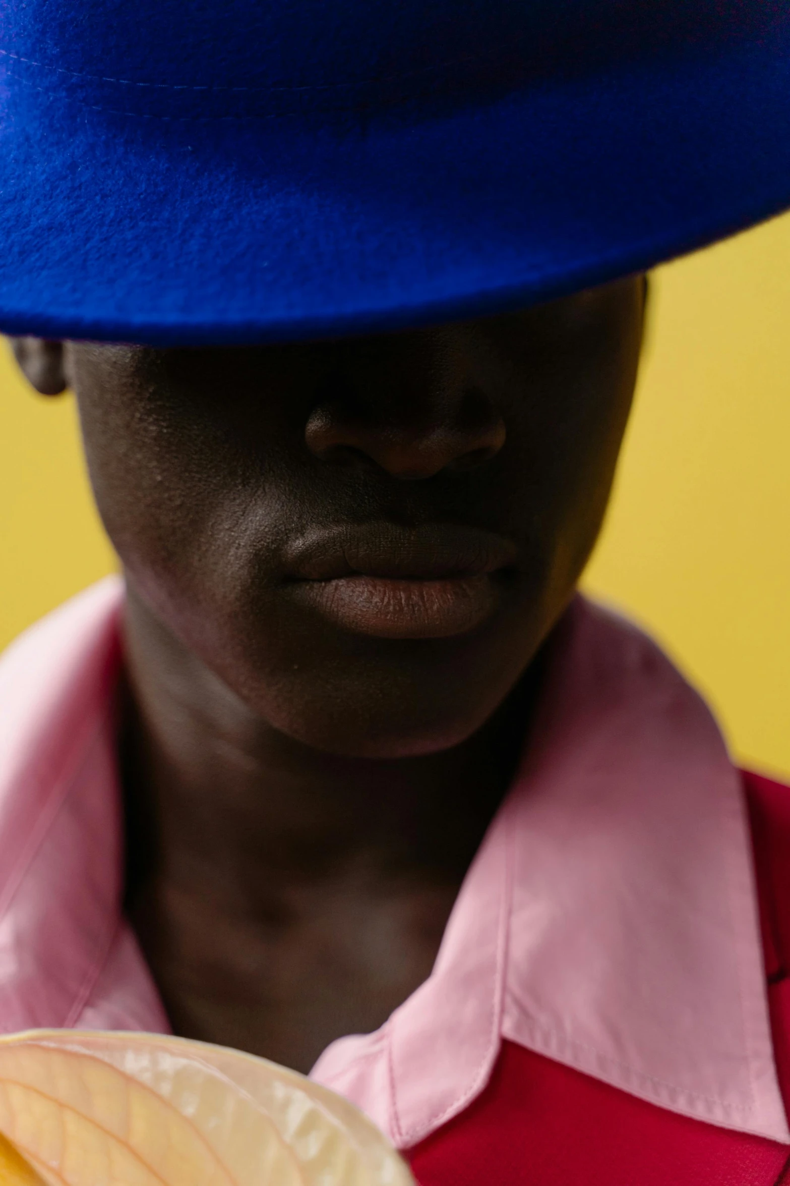 a woman wears a hat and holds a banana