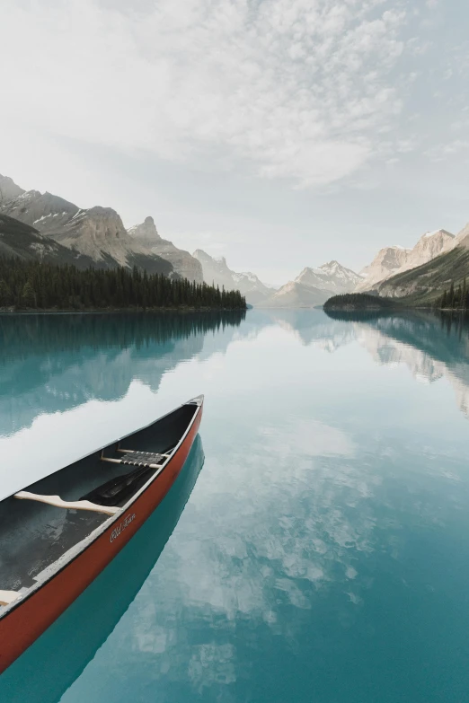 a canoe floats on a lake surrounded by mountains