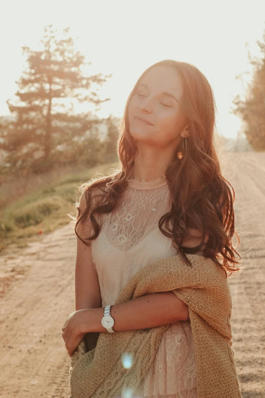 woman with eyes closed walking away from the sun