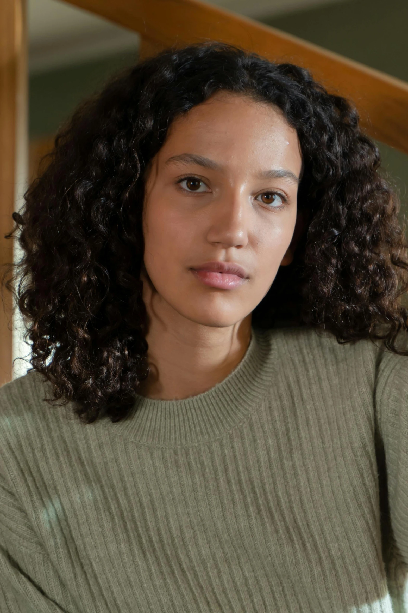 a young woman is sitting down while looking at the camera