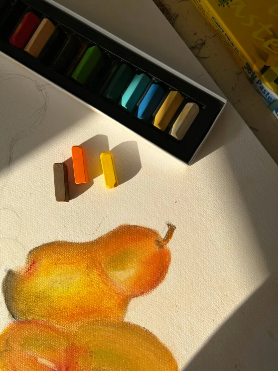 an image of a painting with crayons and a pear on the table