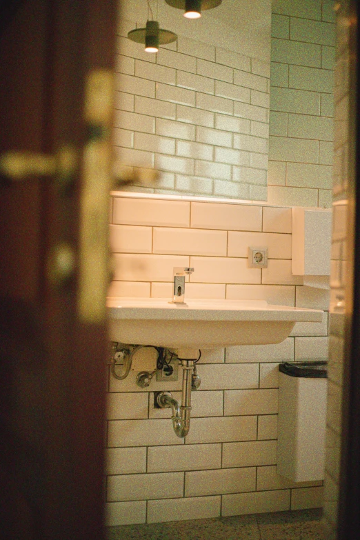 a bathroom sink, mirror and light in an empty room