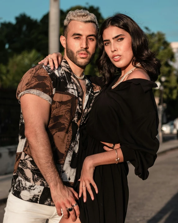 a man and woman standing next to each other in the street