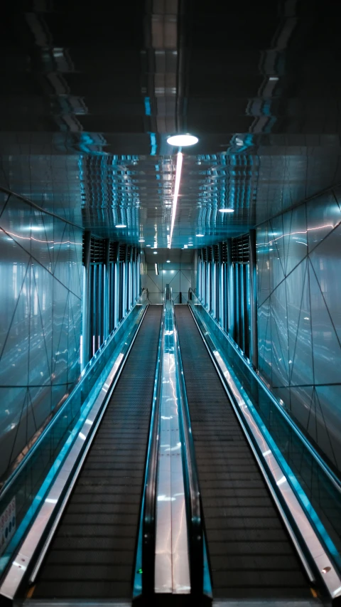 empty escalators and benches in the center of a subway station