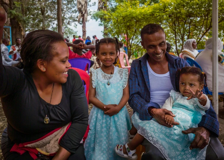 several people and two children sit together