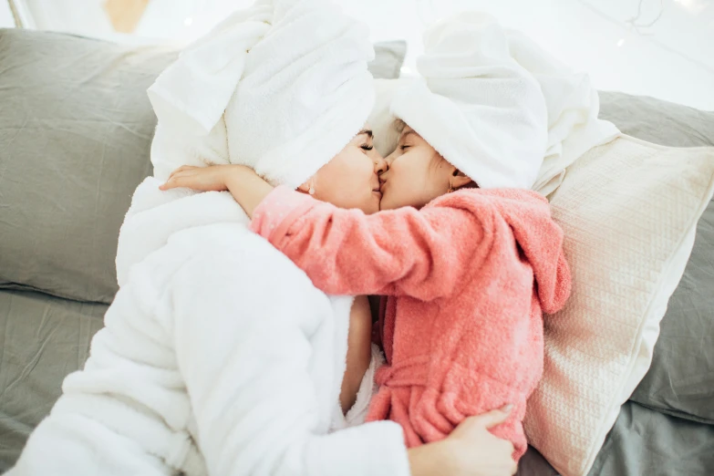 a mother is holding her child wrapped in a blanket