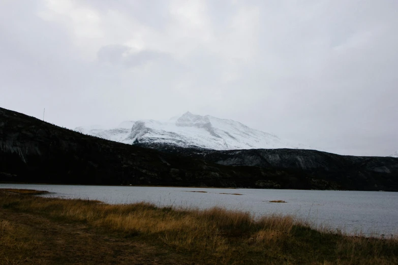 the mountain is next to the lake with water