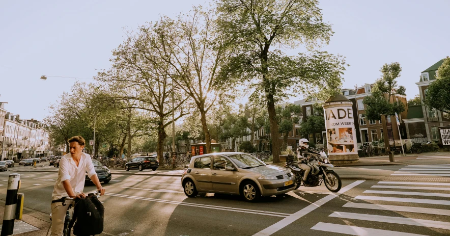 a woman crossing the street on a bike