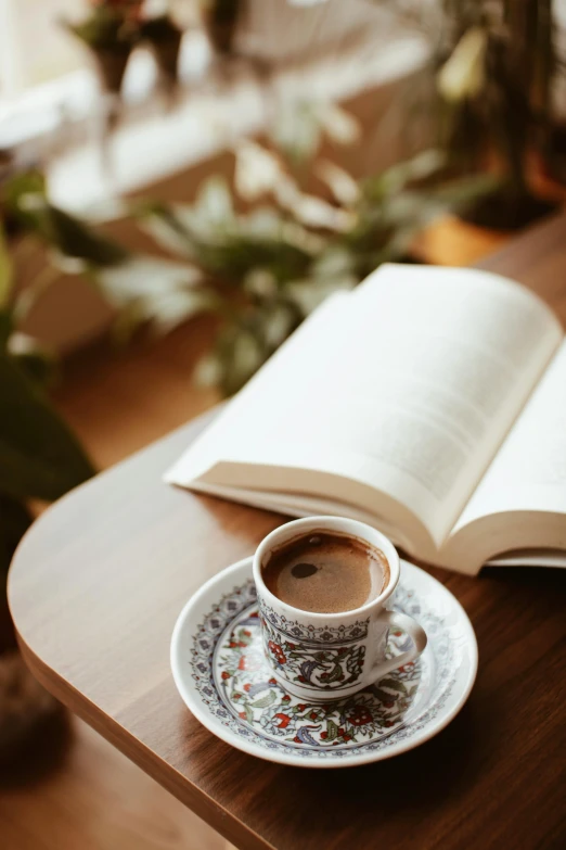 a book and a cup on a table with a coffee