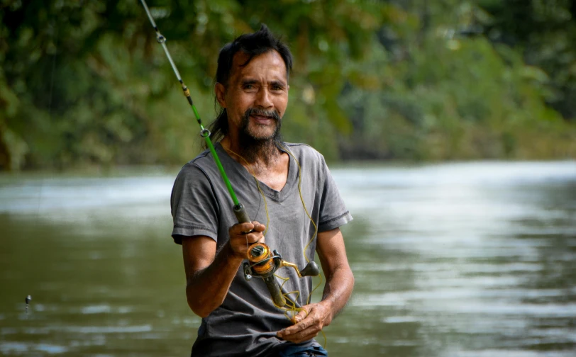 a man standing in a flooded area holding a snake