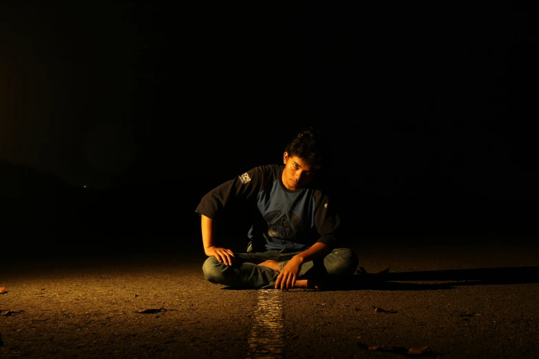 a man sits on the ground, waiting for soing to happen