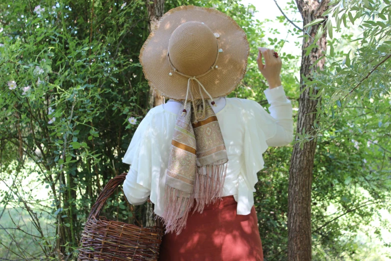 the woman is dressed in a red dress and straw hat