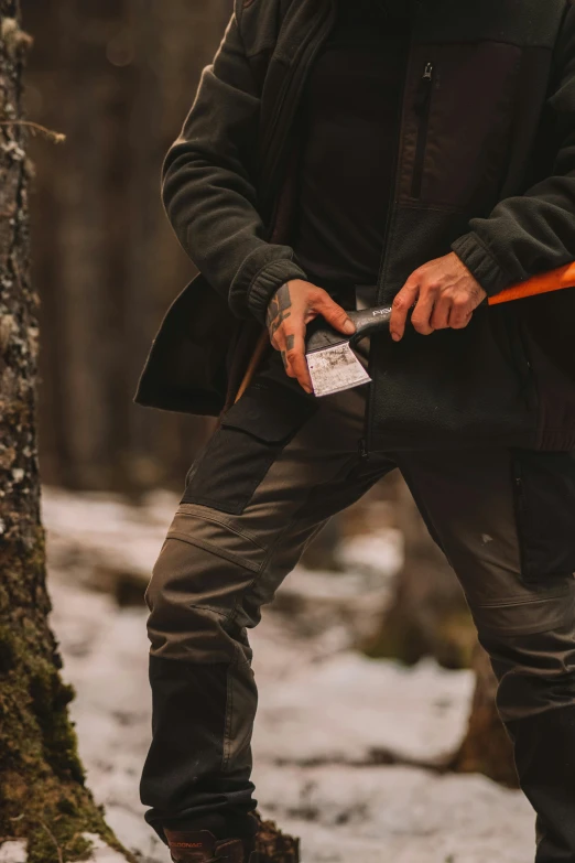 man standing in the snow holding an axe