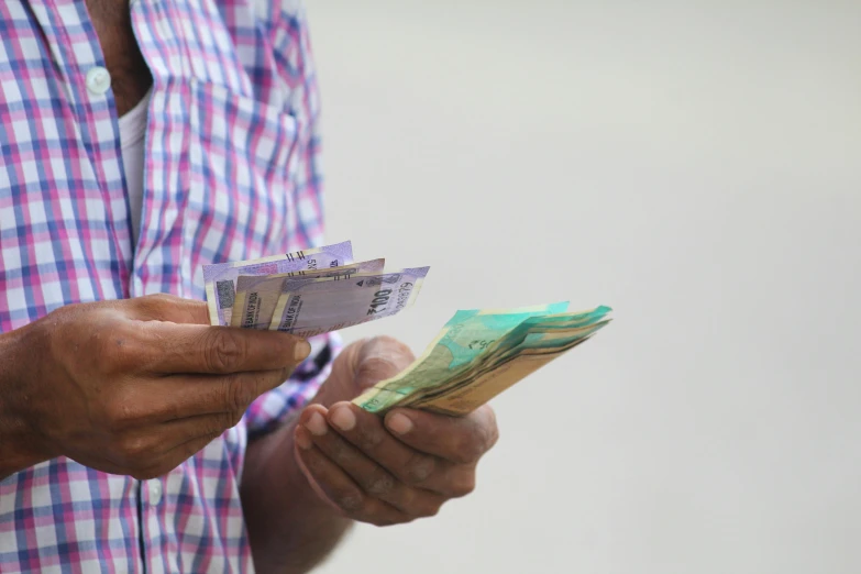 a man is holding money with a white background