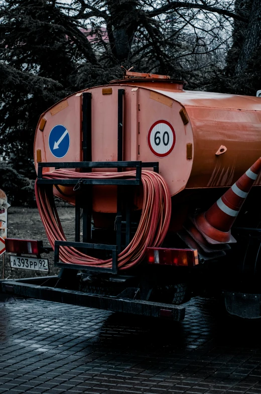 a truck with orange hoses sits on the side of the road