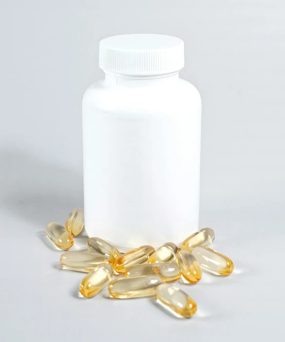 an overflowing bottle and golden pills sitting on the ground