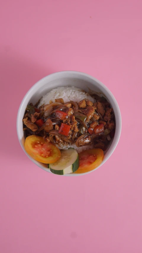 a bowl with rice, meat and vegetables in it