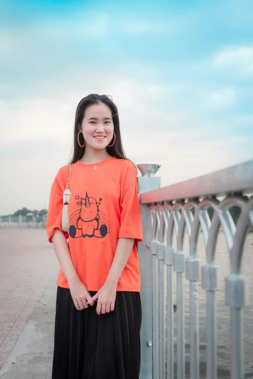 a girl standing on a street with a fence behind her