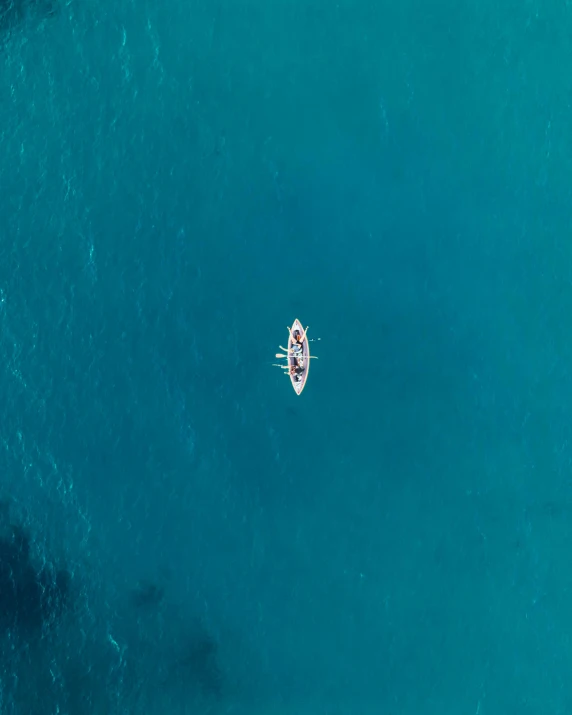 an aerial view of a person rowing a boat