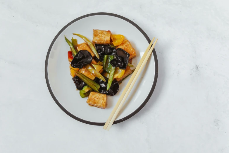 tofu, green beans and other vegetables served on a white plate