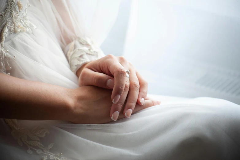 a bride holding her hands on top of the dress