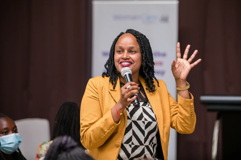 woman talking into microphone at public event